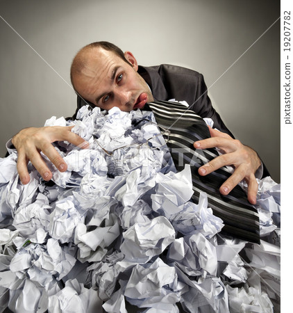 Exhausted depressive businessman laying on crumpled papers 19207782