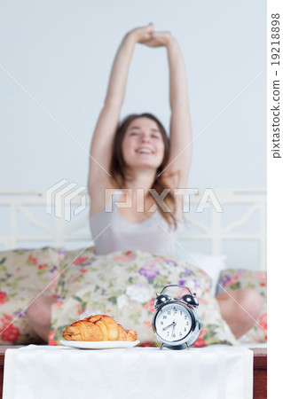 The young girl in bed with  clock service 19218898
