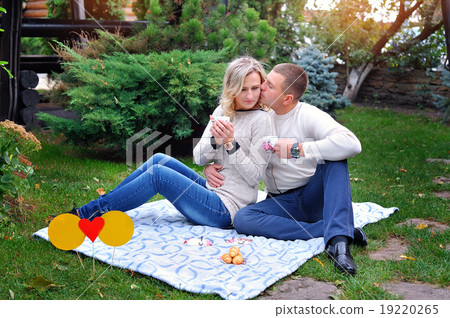 love couple sitting on a bed in the park having a picnic love couple sitting on a bed in the park having a picnic 19220265