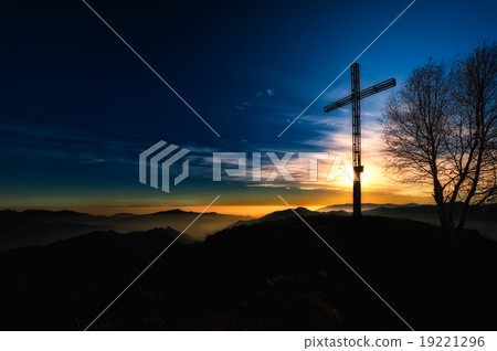 Summit cross a mountain at sunset 19221296