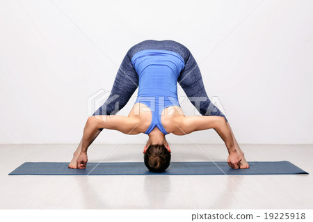 Sporty woman practices Ashtanga Vinyasa yoga asana 19225918