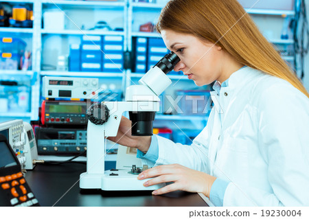 Scientist using a microscope in a laboratory Scientist using a microscope in a laboratory 19230004