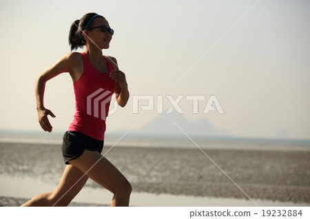 young fitness woman running at sunrise beach 19232884