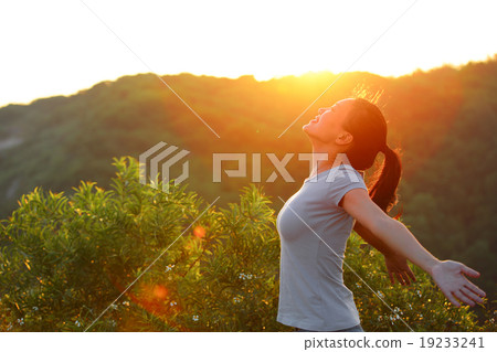cheering woman open arms at sunrise mountain peak 19233241
