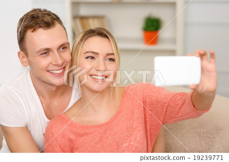 Young happy couple is busy taking selfie. Young happy couple is busy taking selfie. 19239771