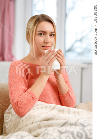 Young attractive woman drinking tea at home. Young attractive woman drinking tea at home. 19239800