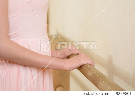 Woman holding on ballet bar.  19239801