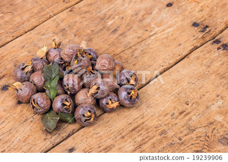 Healthy ripe Medlars on the old wooden table 19239906