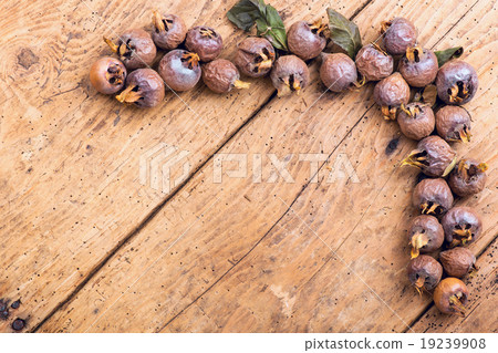Healthy ripe Medlars on the old wooden table 19239908