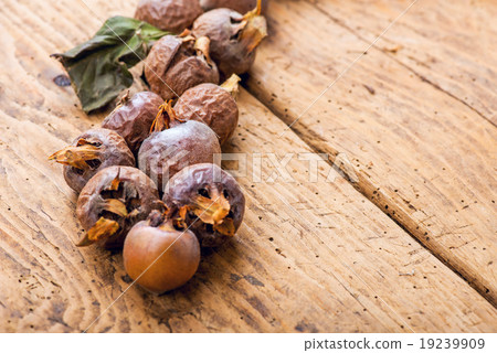 Healthy ripe Medlars on the old wooden table 19239909