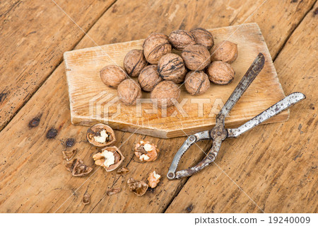 walnuts and nutcracker on an old rustic table 19240009