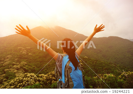 cheering woman hiker open arms at mountain peak cheering woman hiker open arms at mountain peak 19244221