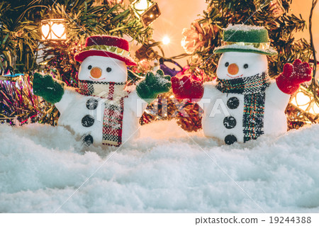 Snowman stand among pile of snow with a light bulb Snowman stand among pile of snow with a light bulb 19244388