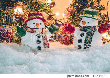 Snowman stand among pile of snow with a light bulb Snowman stand among pile of snow with a light bulb 19244389