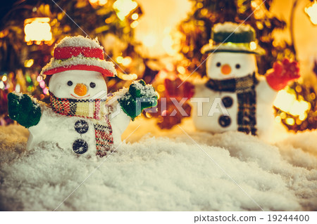 Snowman stand among pile of snow with a light bulb Snowman stand among pile of snow with a light bulb 19244400