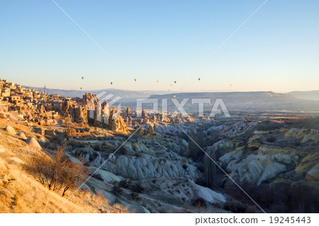 Turkey · Cappadocia A rocky group shining in the morning sun and a balloon 19245443