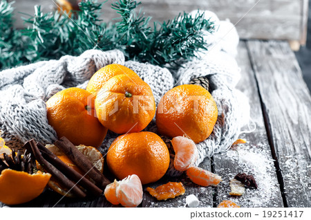 Tangerine in scarf over wooden background Tangerine in scarf over wooden background 19251417