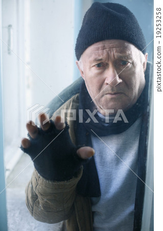 Homeless man looks out of the window. Homeless man looks out of the window. 19253258