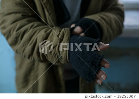Homeless man fixing his gloves. Homeless man fixing his gloves. 19253307