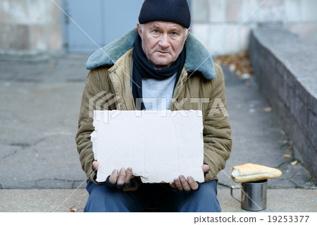 Homeless man holding a cardboard sign. 19253377
