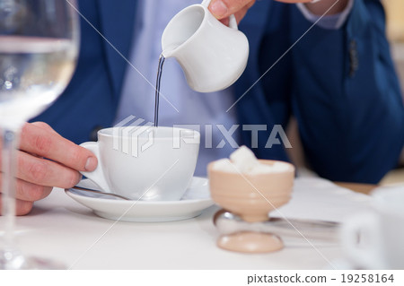Cheerful young man is resting in cafe Cheerful young man is resting in cafe 19258164