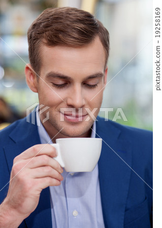 Attractive businessman is enjoying coffee at Attractive businessman is enjoying coffee at 19258169