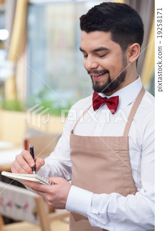 Attractive young waiter is receiving an order Attractive young waiter is receiving an order 19258171