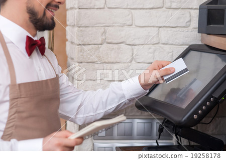 Cheerful young waiter is working with checking Cheerful young waiter is working with checking 19258178