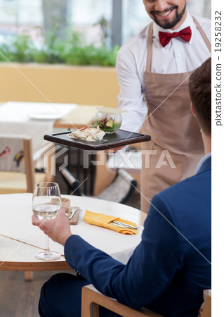 Skillful male cafe worker brings the order of Skillful male cafe worker brings the order of 19258232