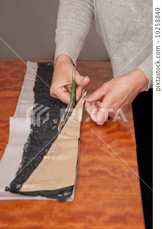 Cutting the cloth in atelier with scissors Cutting the cloth in atelier with scissors 19258849