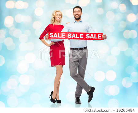 happy couple with red sale sign over blue lights 19266494