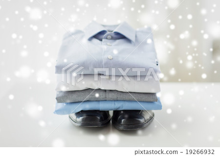 close up of folded male shirts and shoes on table close up of folded male shirts and shoes on table 19266932