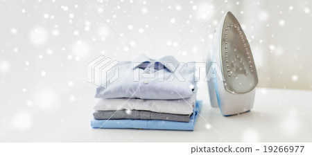 close up of iron and clothes on table at home 19266977