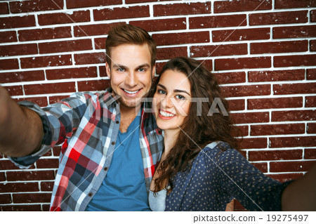 Concept for stylish young couple near brick wall Concept for stylish young couple near brick wall 19275497