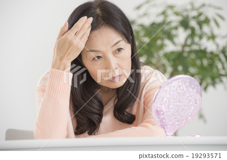 一個50多歲的女人正在看鏡子 一個50多歲的女人正在看鏡子 19293571