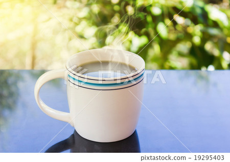 Classic white cup of black coffee with tree background Classic white cup of black coffee with tree background 19295403