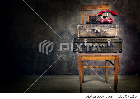 Vintage suitcase with phone on chair 19307129