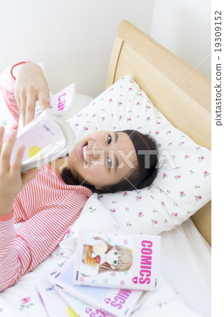 A girl reading a manga 19309152