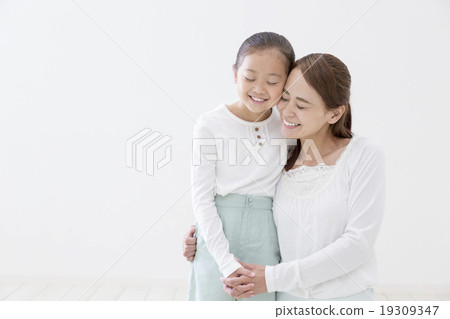 Mother and daughter bringing cheeks together 19309347