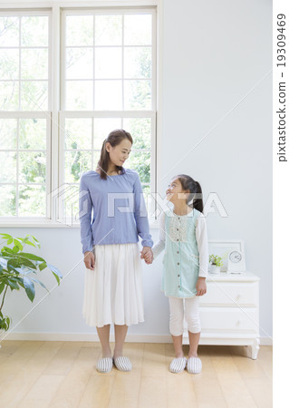 Mother and daughter standing by hand 19309469