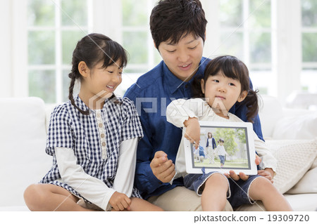 Parent and child sitting on the sofa with a tablet PC Parent and child sitting on the sofa with a tablet PC 19309720