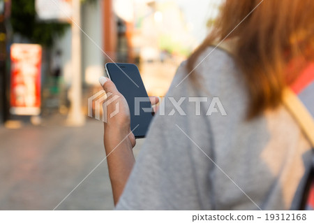 woman holding phone navigation travel in city 19312168