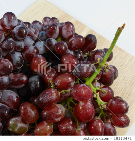 The large bunch of ripe red grapes on the wooden b 19313471