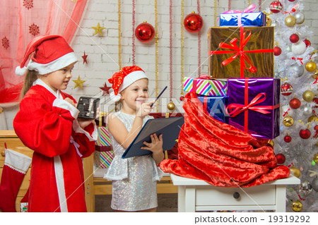 Santa and helper happily recount gifts in a bag and checked against the list 19319292