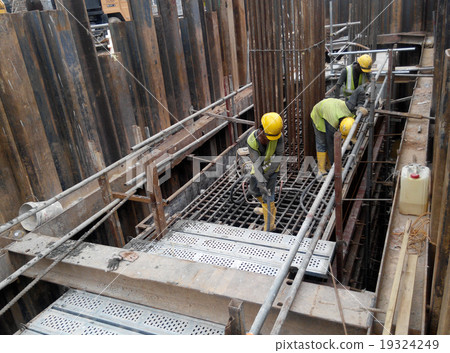 Workers using concrete vibrator  19324249