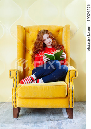 Happy woman relaxing at home and reading a book Happy woman relaxing at home and reading a book 19324376