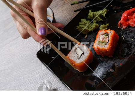 Sushi. Hand with chopsticks 19326934