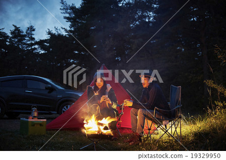 A couple to relax in front of a bonfire A couple to relax in front of a bonfire 19329950
