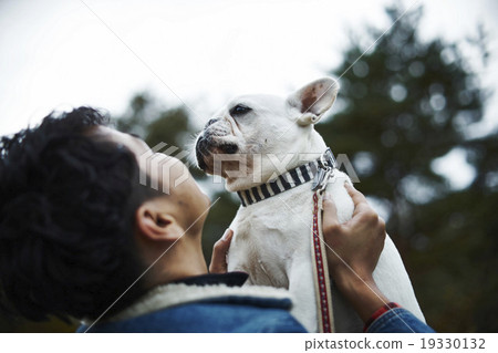 A man holding a pet dog A man holding a pet dog 19330132