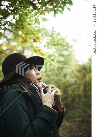 A woman walking through the forest A woman walking through the forest 19330134